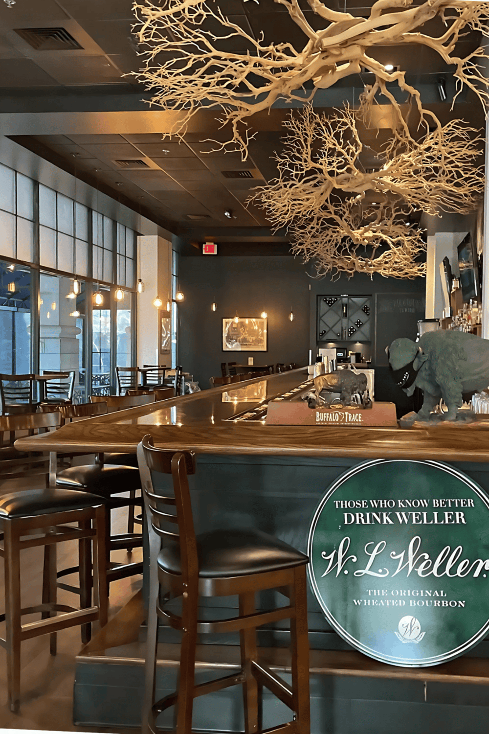 Lush interior of a restaurant featuring decorative tree branches on the ceiling.
