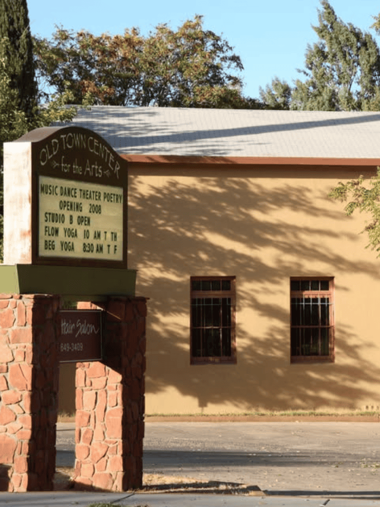 Colorful old town center for arts with yoga studio and dance classes signage in bright sunlight.
