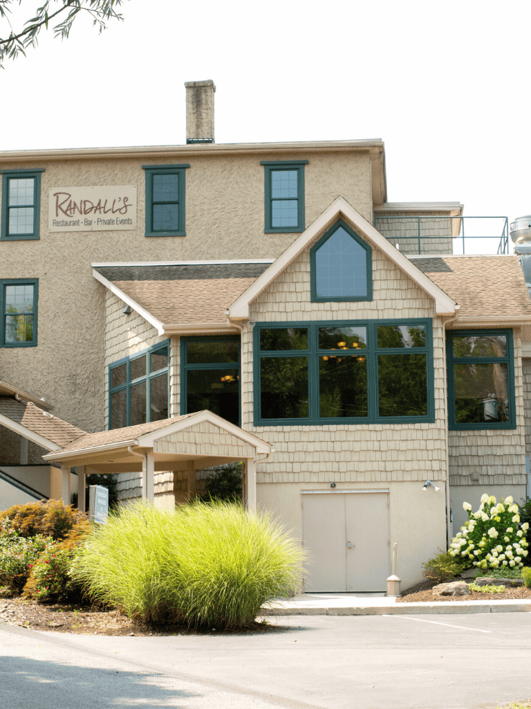 Modern residential building with a restaurant and private event space, featuring large windows and landscaped surroundings.