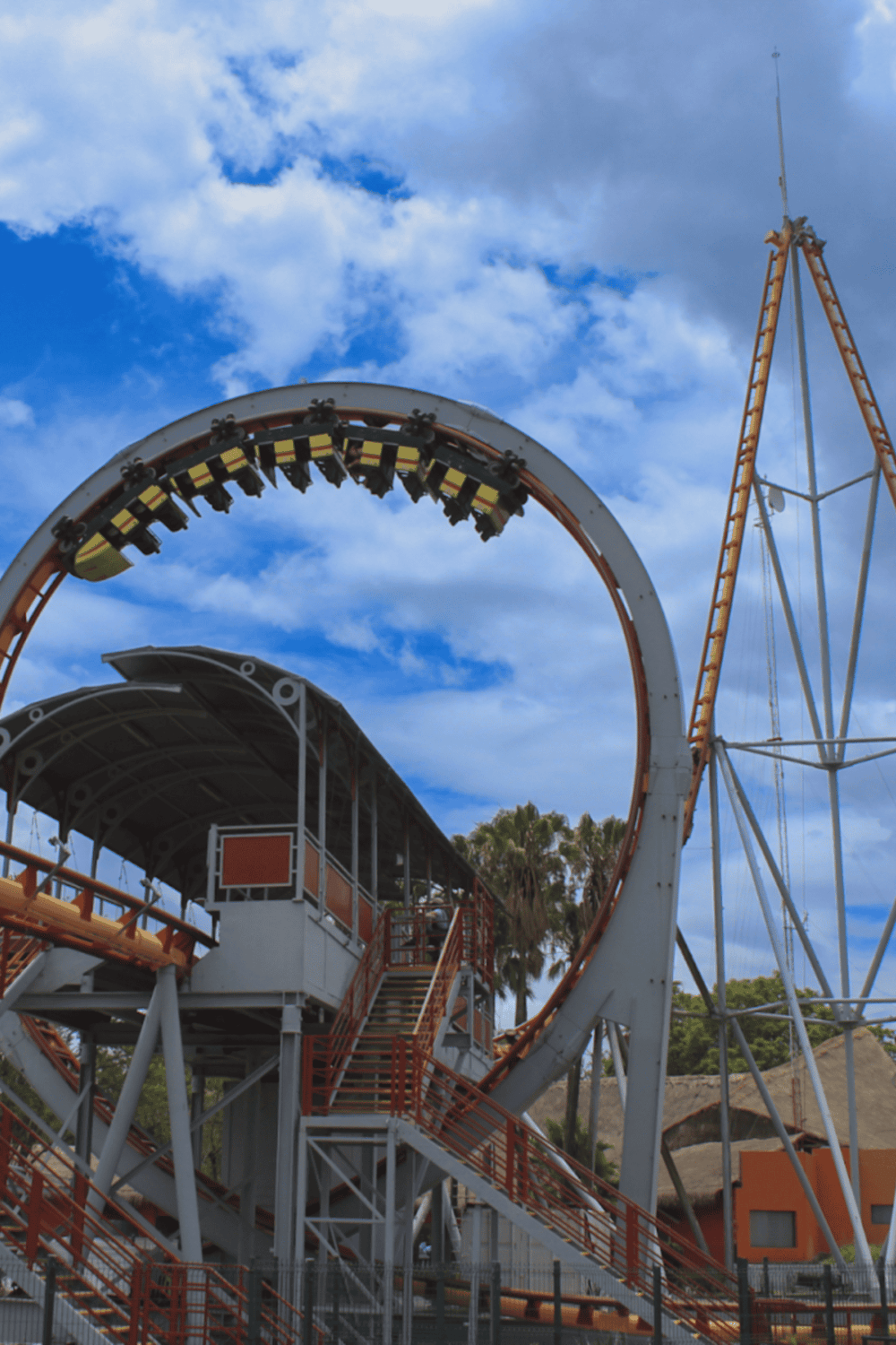 Thrilling roller coaster ride at an amusement park under a bright blue sky.