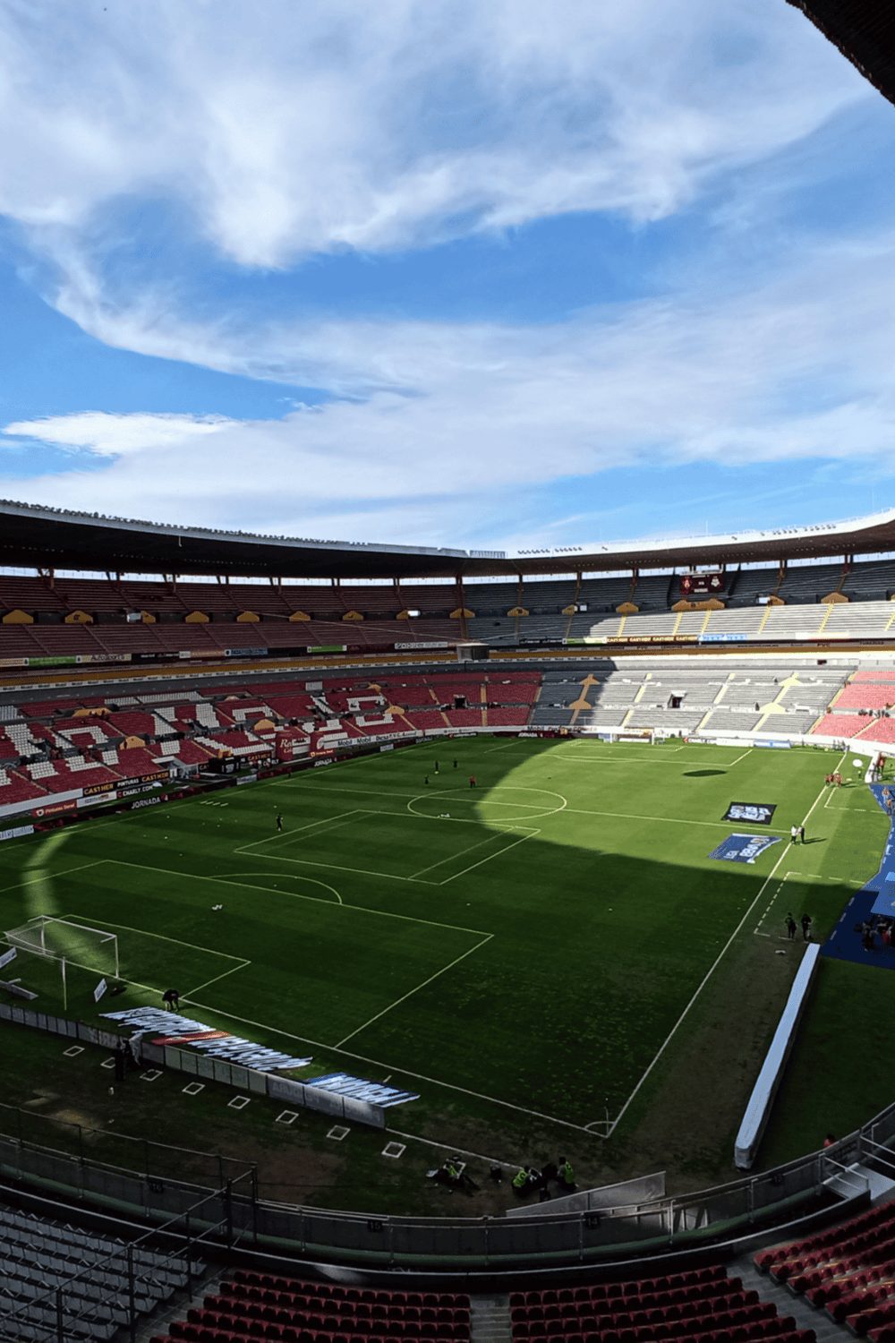 Bright stadium football field for soccer matches with seating area and clear sky.
