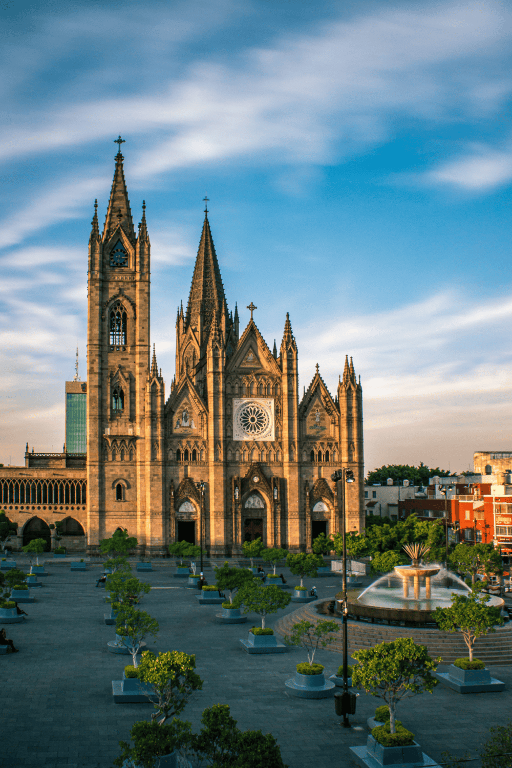 Historic Gothic cathedral with stained glass windows and towering spires in an urban setting.