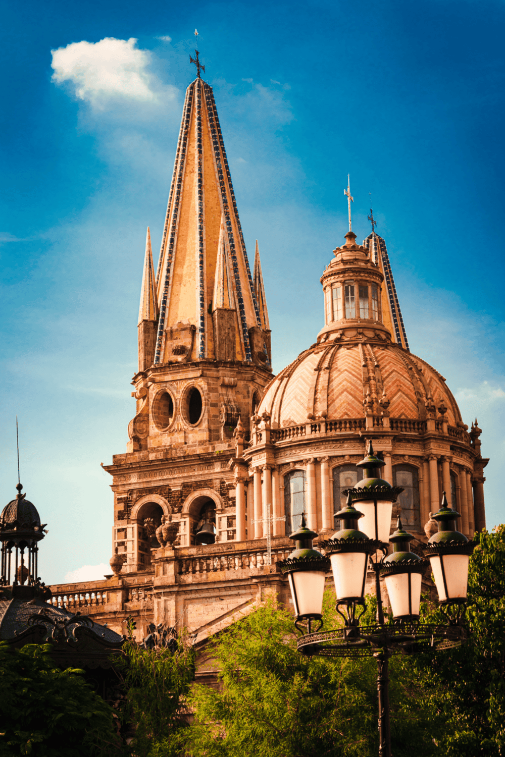 Vibrant view of historic church with tall steeples and ornate architecture in Mexico City.