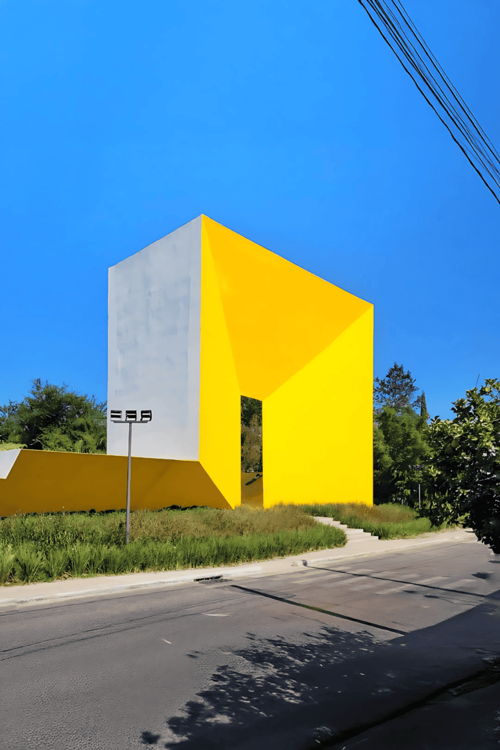 Colorful modern building with yellow and white geometric design on street, emphasizing architecture and urban exploration.