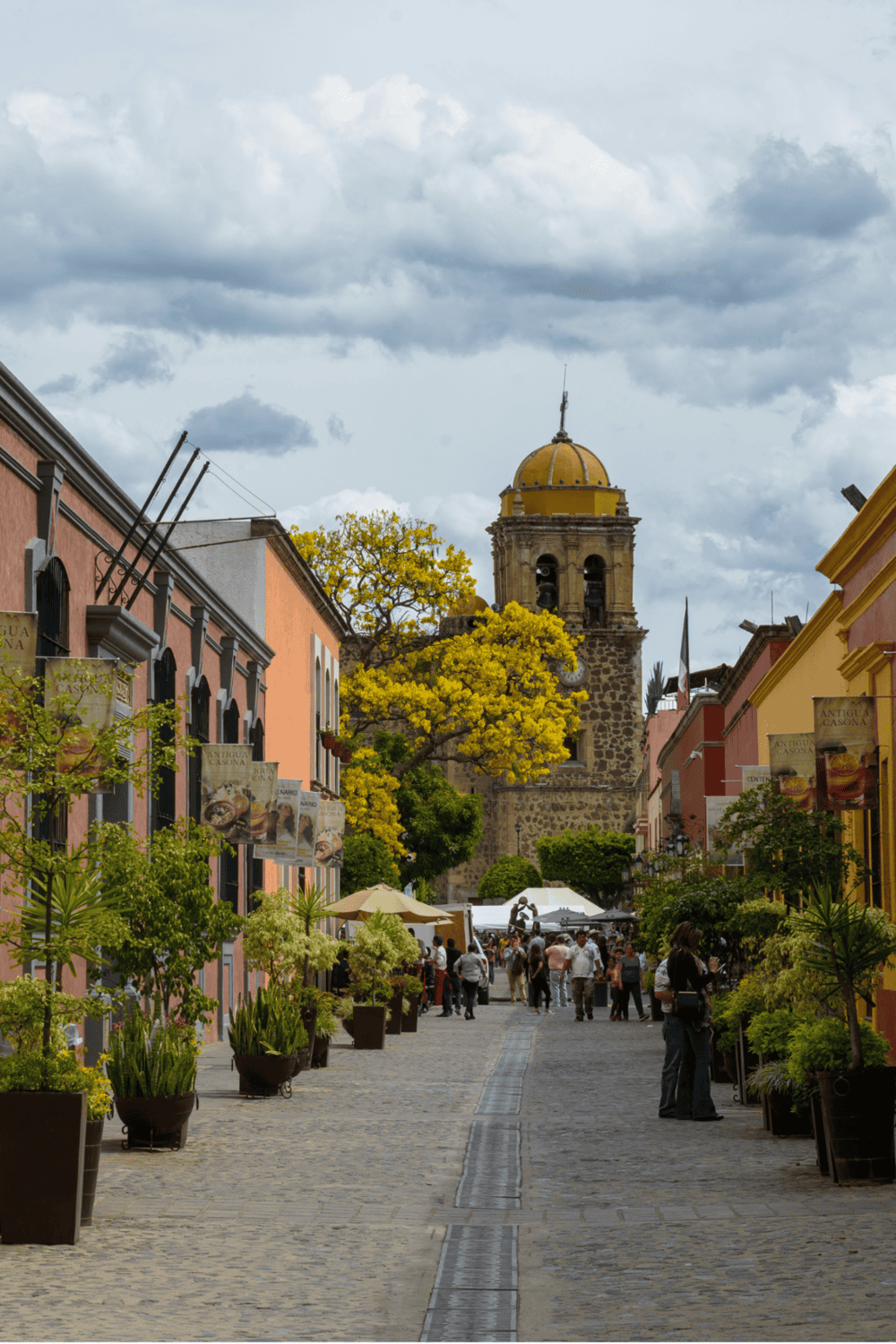 Colorful street in San Miguel de Allende with vibrant buildings, lively atmosphere, and historic architecture.