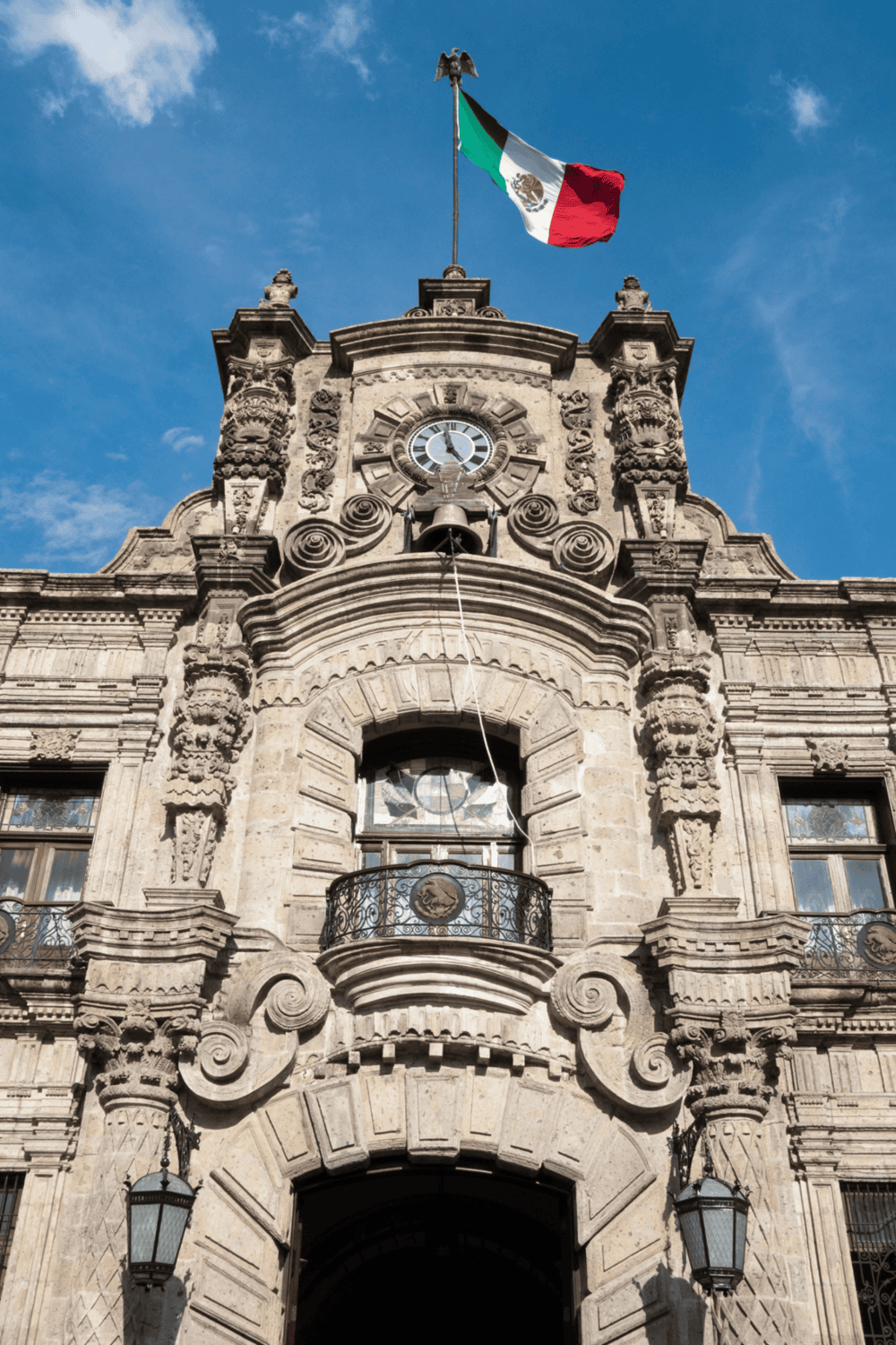Flag of Mexico on historic government building in Mexico City.