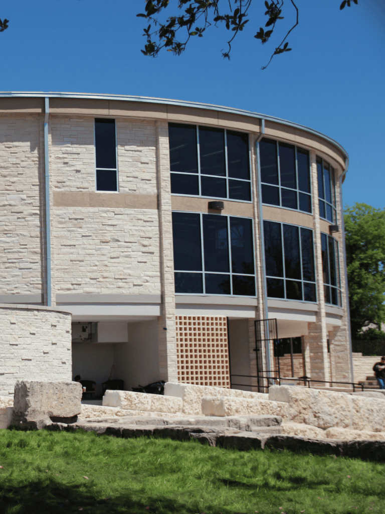 Modern architecture building with large glass windows and stone exterior, QuestForDirections location.