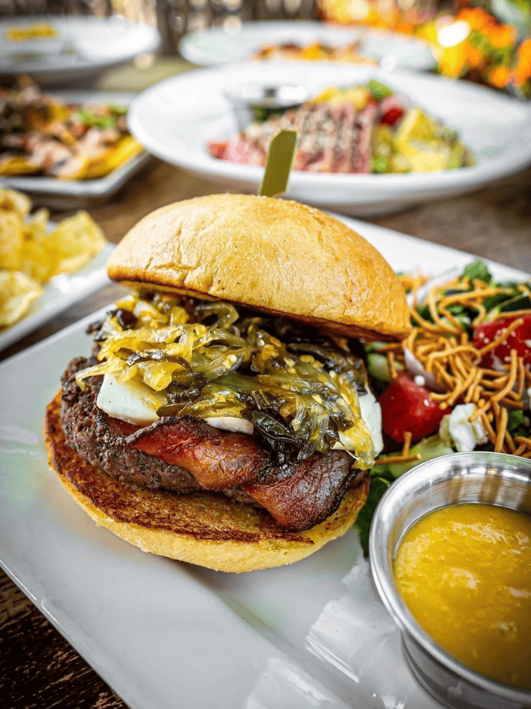 Savory barbecue beef burger with pickled vegetables and side salad, gourmet casual dining.