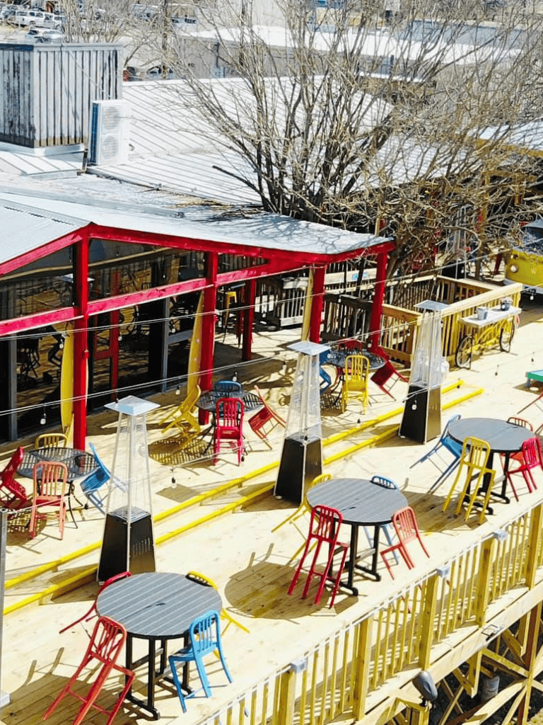 Colorful outdoor dining area with tables and chairs at a restaurant or cafe.