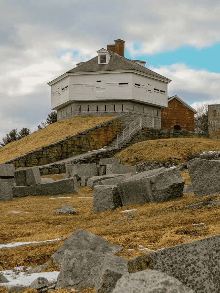 1. Historic house elevated on hill with stonework and stairs, scenic autumn landscape, cloudy sky.