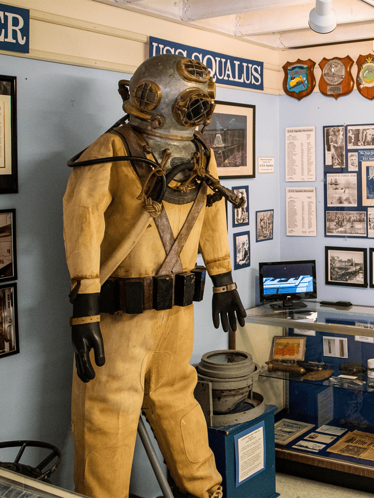 Deep-sea diver suit exhibit at Quest for Directions maritime museum, showcasing historical exploration gear.