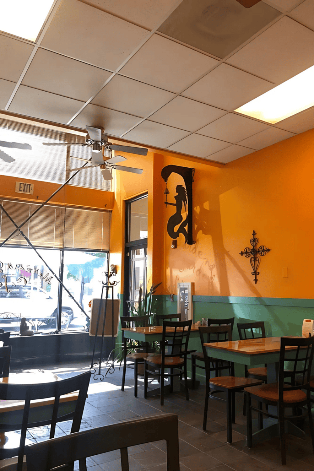 1. Cozy cafe interior with vibrant orange and teal walls, sea-inspired decor, and natural sunlight.