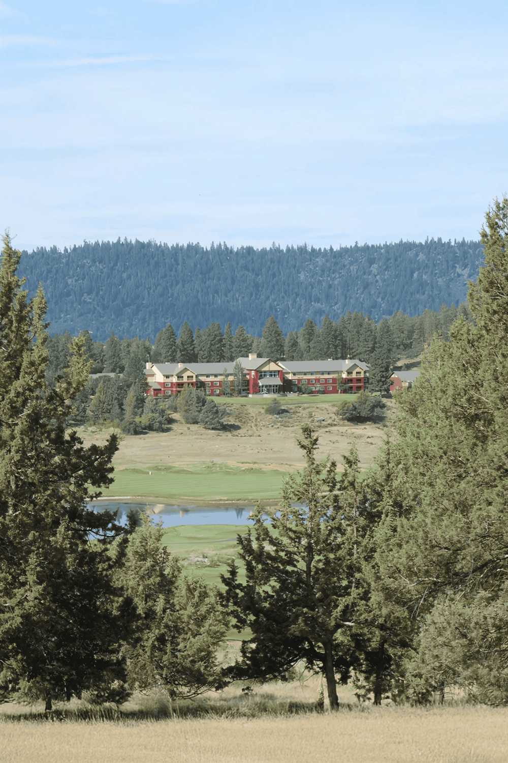 Luxurious mountain resort with scenic views of forests and a golf course.