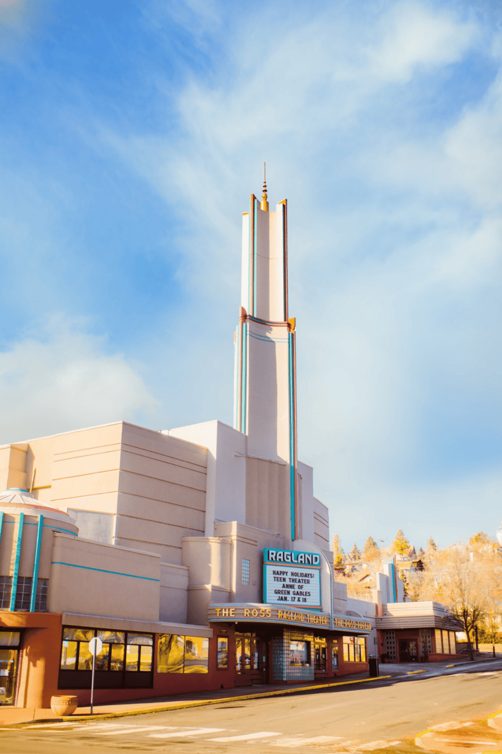 Colorful neon-lit theater building with Art Deco design, home to Quest for Directions entertainment.