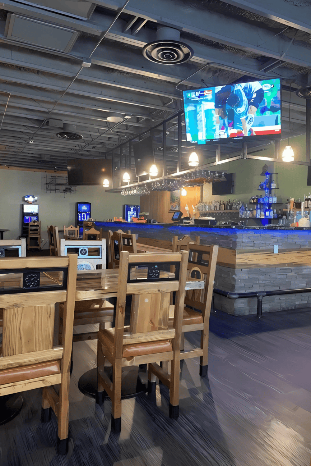 1. Modern sports bar with large TV screens, wooden tables, and a vibrant atmosphere.