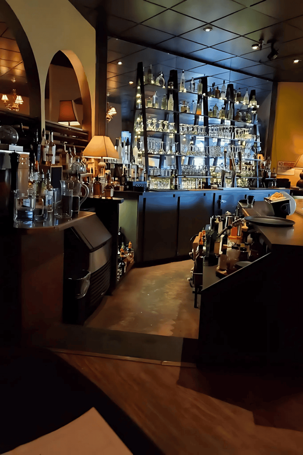 Luxurious bar with glassware and bottles, cozy lighting, perfect for drinks and socializing.