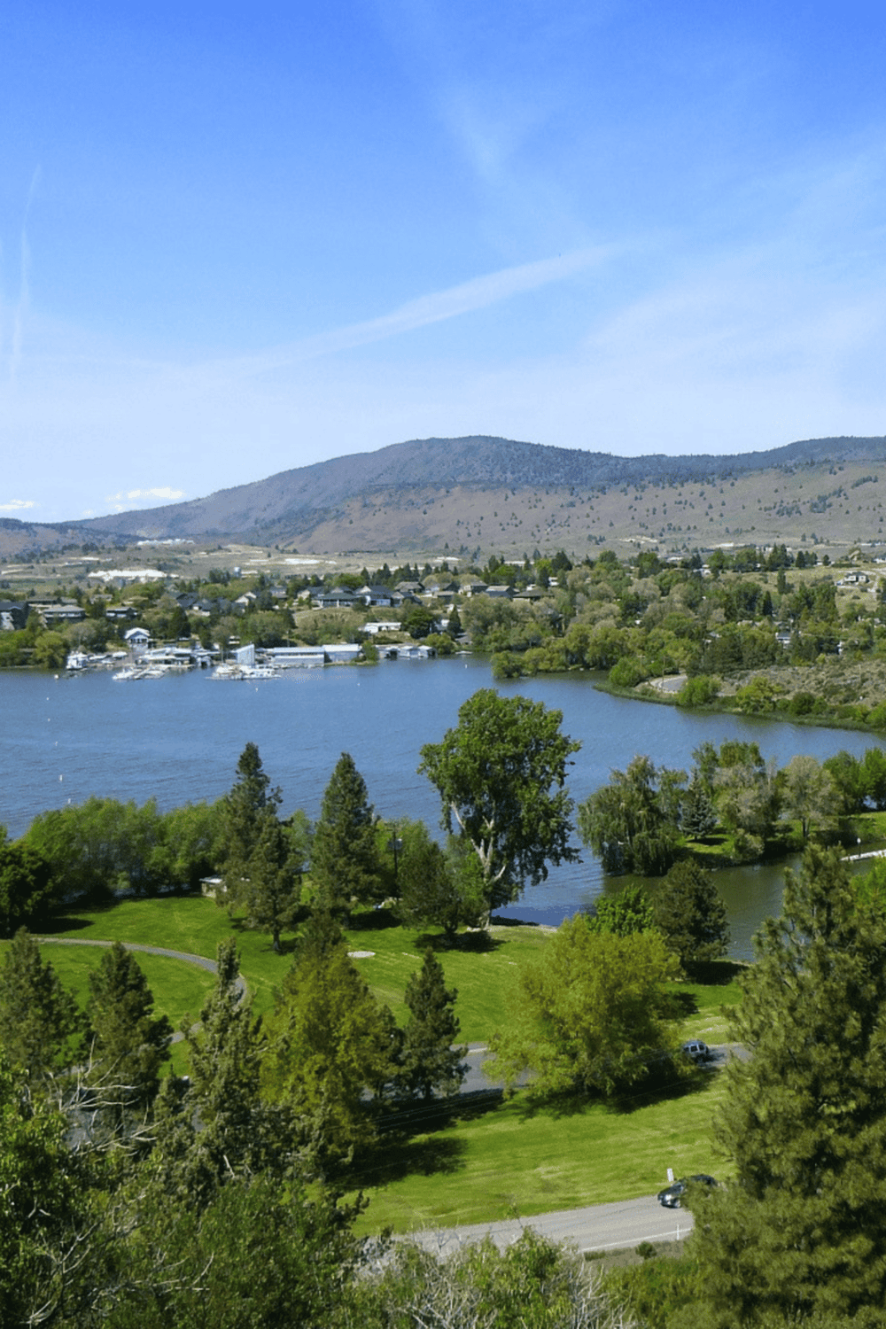 Serene lake view with lush greenery and mountains in the background, ideal for outdoor adventures and scenic exploration.