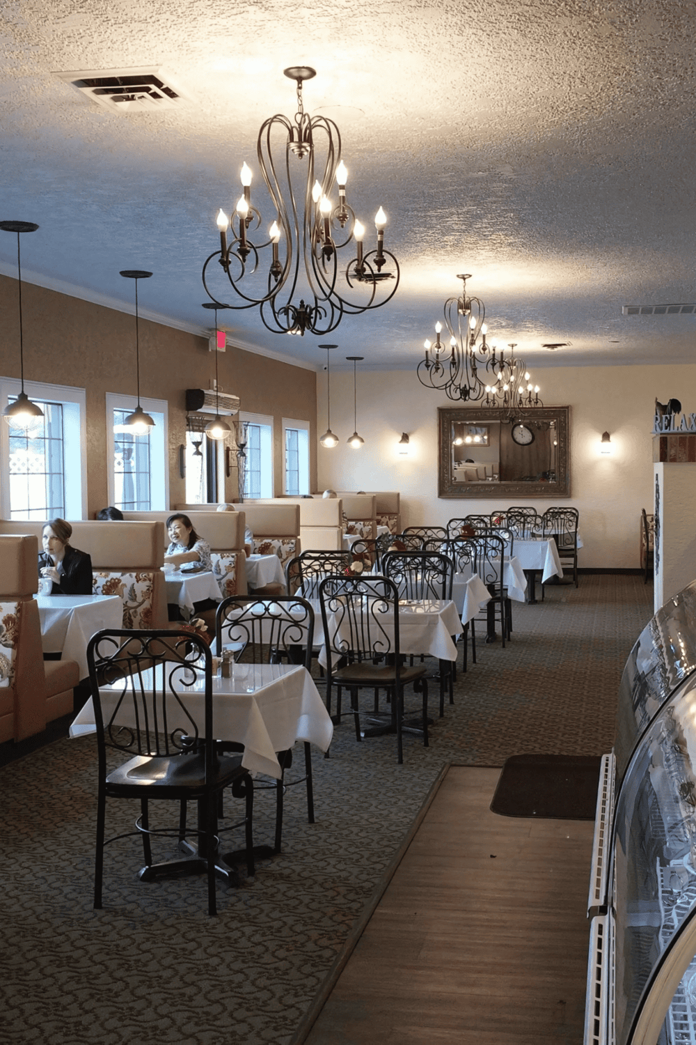 Cozy restaurant interior with elegant chandeliers, stylish lighting, and comfortable seating for dining experiences.