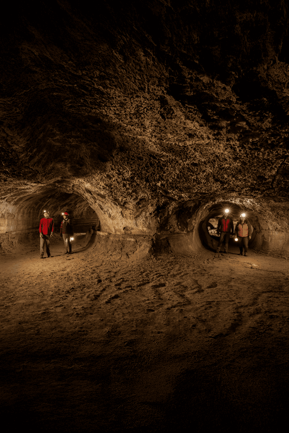 Exploring underground caves with headlamps for adventure and discovery.