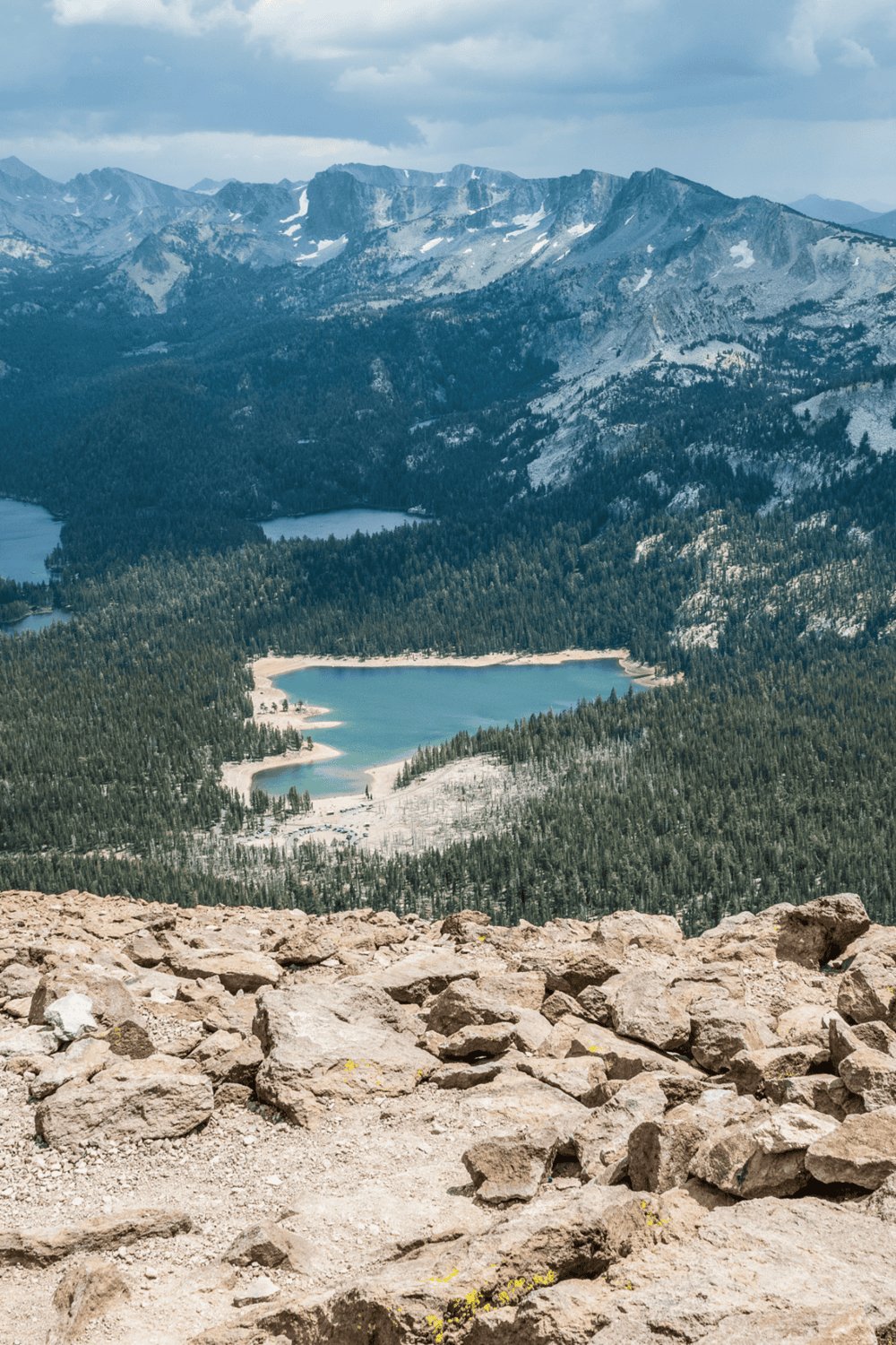 Breathtaking mountain landscape with lakes, forest, and rocky foreground in scenic wilderness.