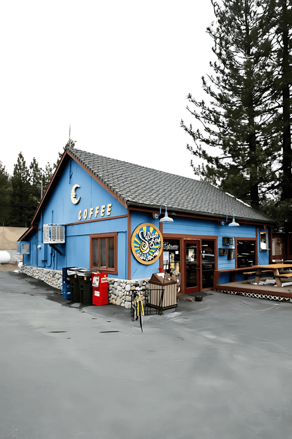 Cozy blue coffee shop with outdoor seating and mountain view, perfect for a relaxing stop during travels.