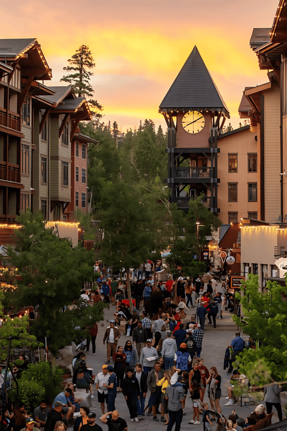 Vibrant outdoor shopping and dining area at sunset in a mountain village, bustling with visitors.