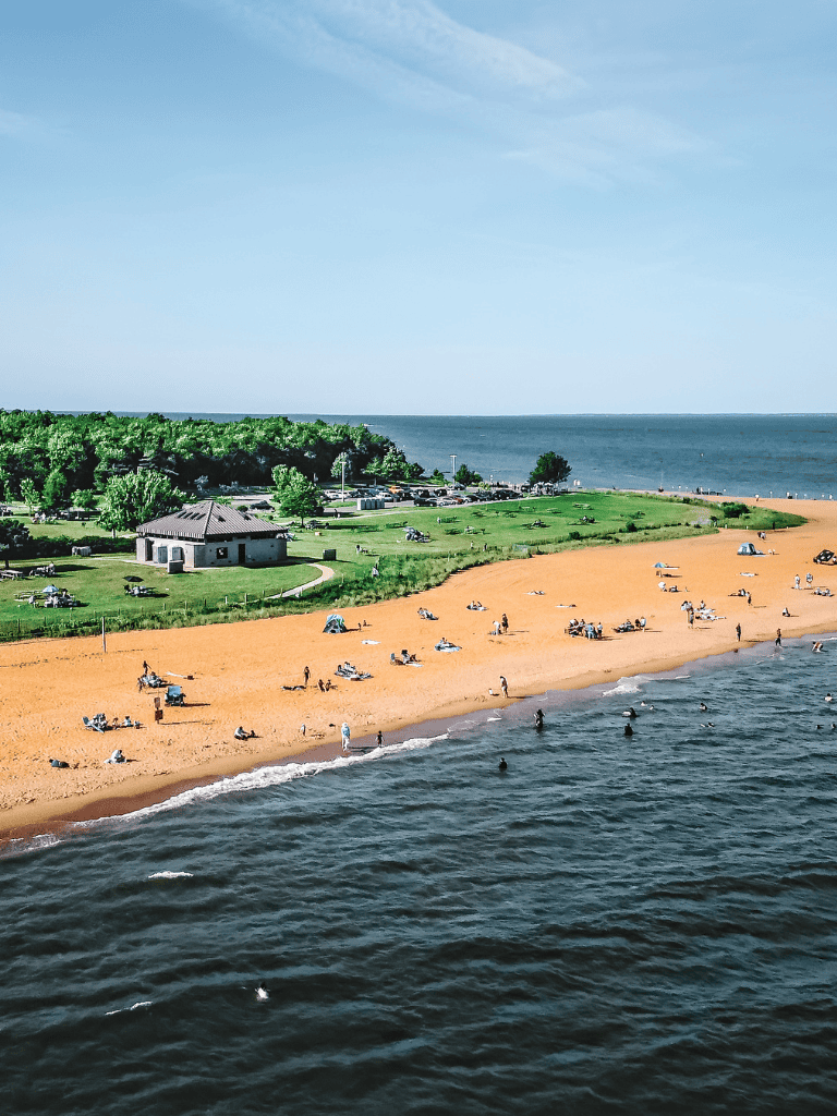 Scenic beach with green park and ocean view, ideal for leisure and outdoor activities.