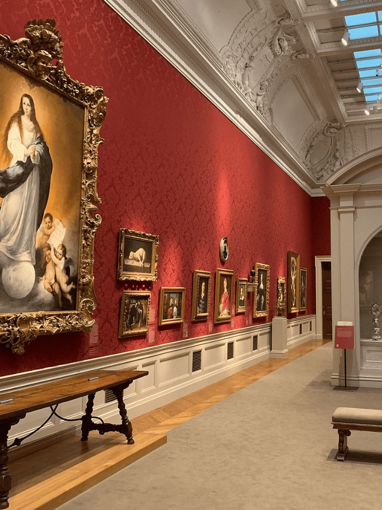 Intricate art gallery with ornate paintings in a luxurious historic museum setting.