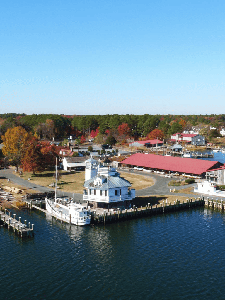 Boat harbor with lighthouse on a sunny day in coastal town.
