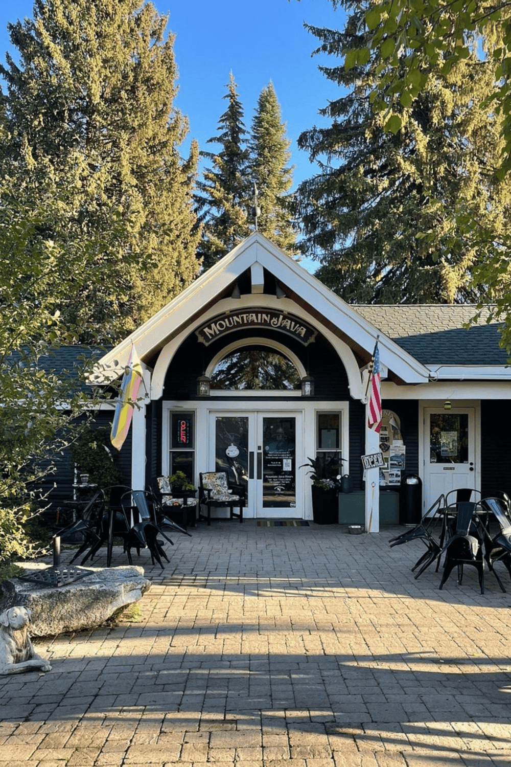Charming Mountain Java coffee shop with outdoor seating surrounded by tall pine trees.