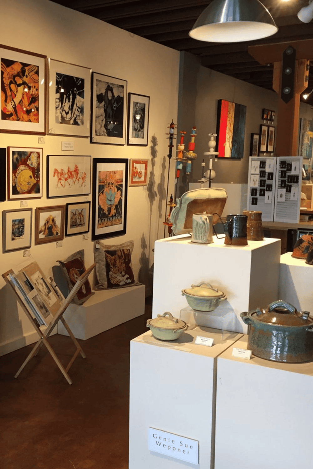 Vibrant art gallery featuring eclectic paintings, ceramics, and textiles with a cozy, creative ambiance.