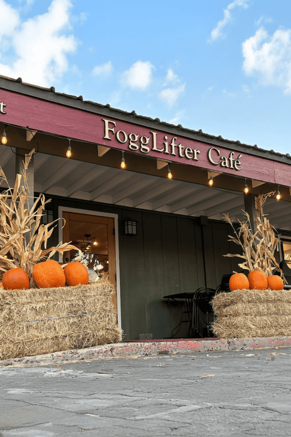 Cozy café exterior with autumn decorations, pumpkins, and hay bales, perfect for fall days.