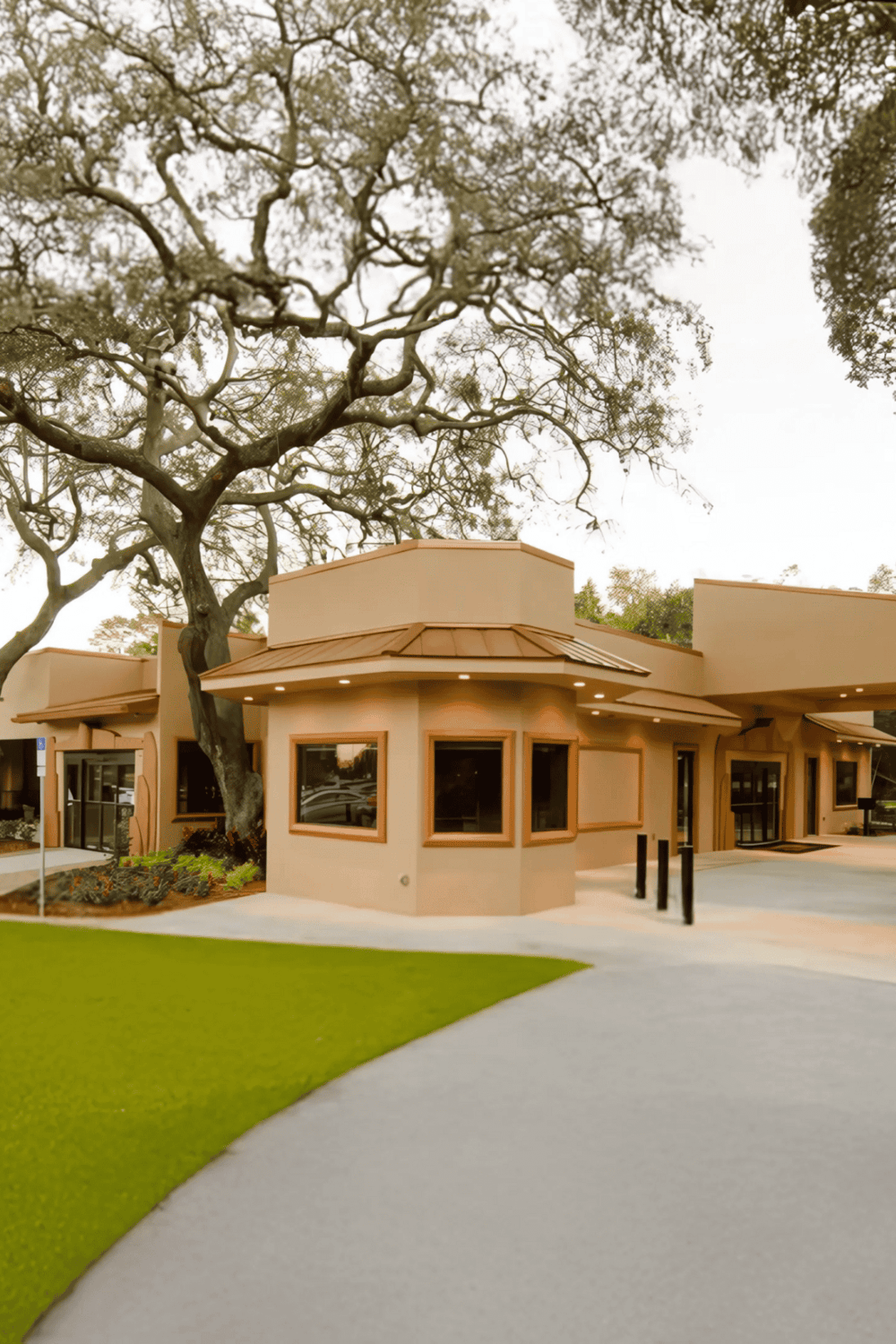 Modern building with large trees, homes for personalized directions, and a natural landscape.