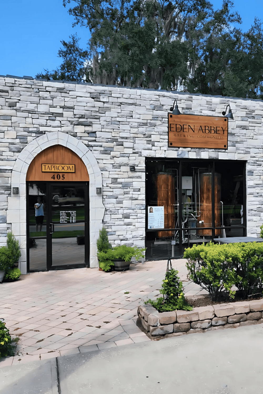 Elegant brewery and taproom entrance at Eden Abbey Brewing Community, featuring stone facade and wooden accents.