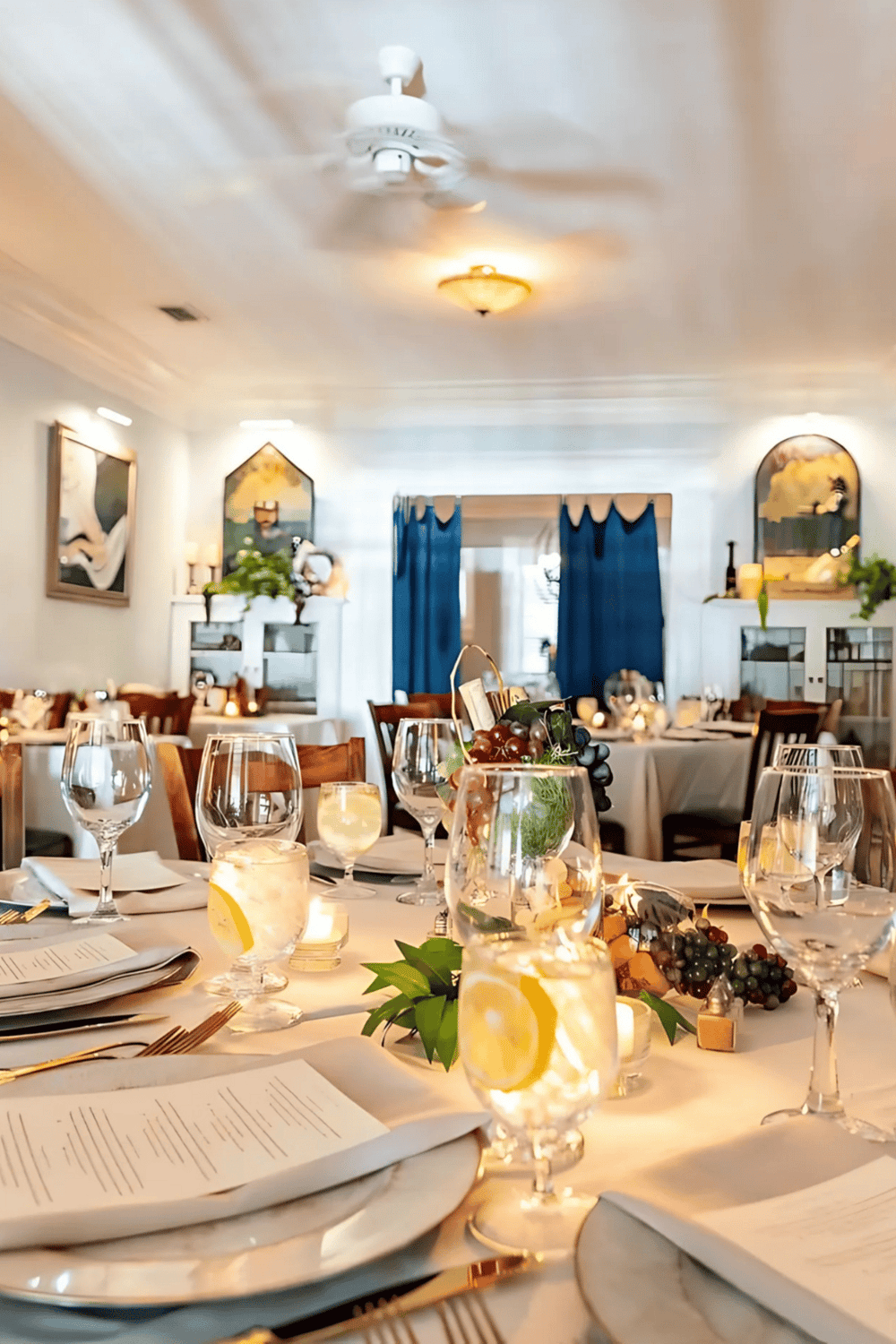 Elegant dining room setup for special events with wine glasses, menus, and floral centerpieces.
