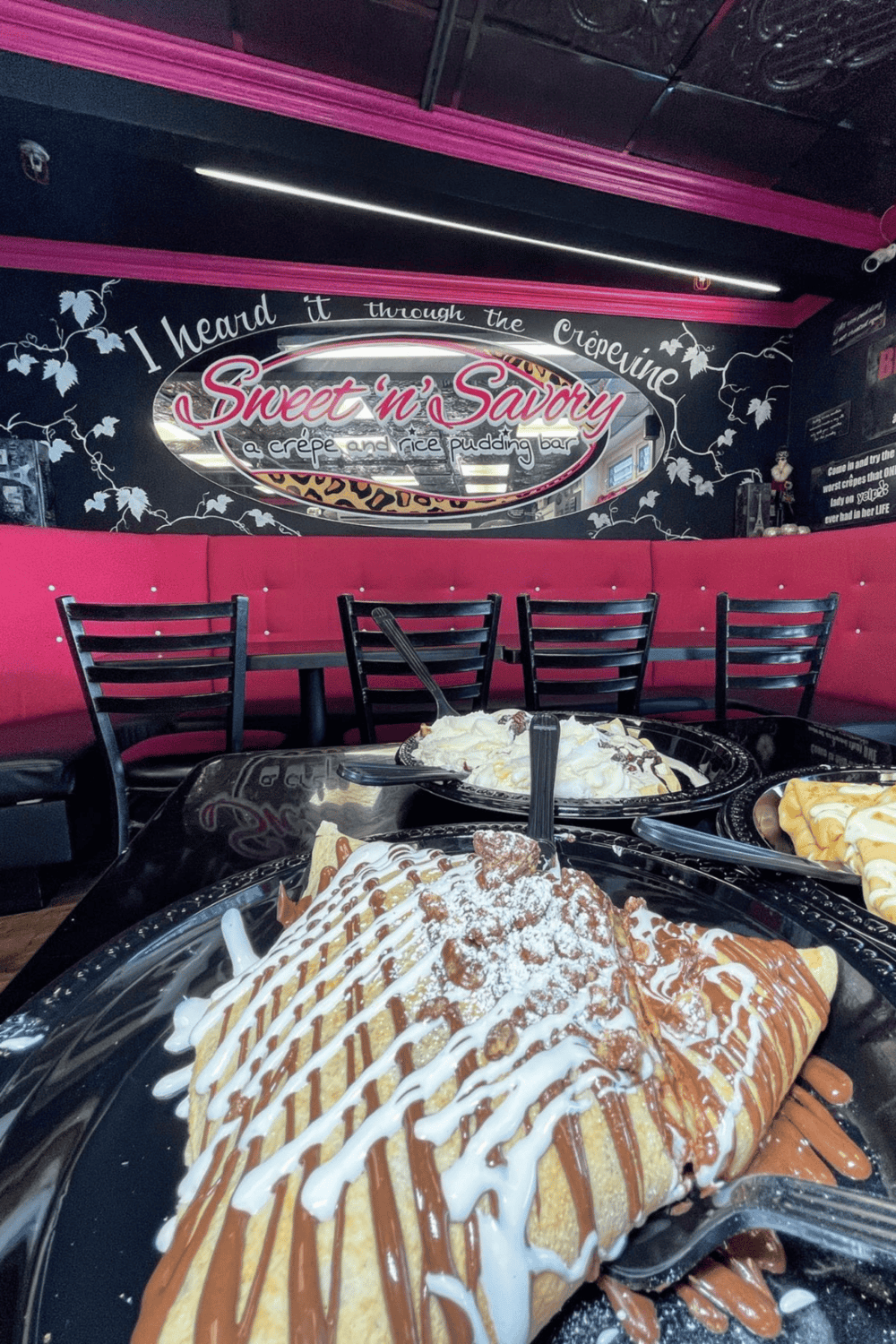 Delicious crepes topped with caramel, whipped cream, and chocolate at a cozy dessert shop.