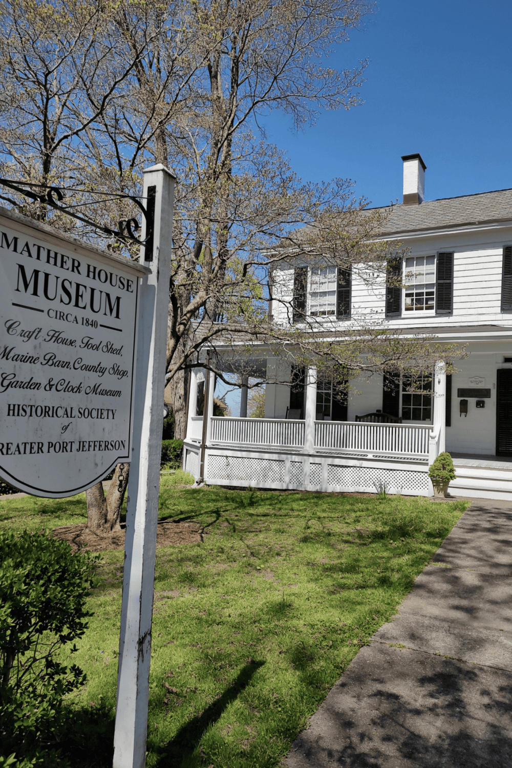 Weathered Museum sign at historic house in Port Jefferson, New York, showcasing local history and architecture.