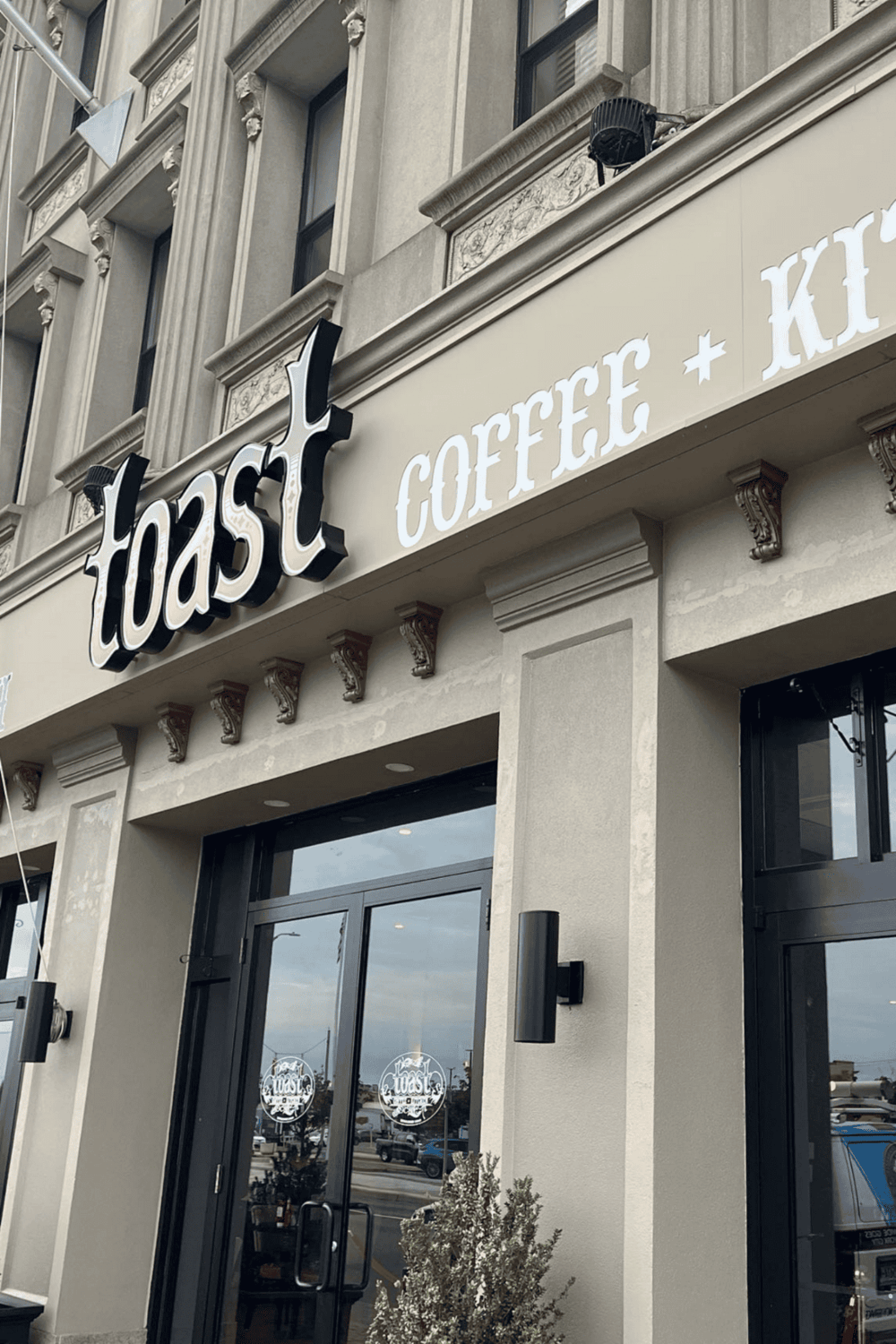 Toast coffee and kitchen restaurant storefront located in a stylish building.