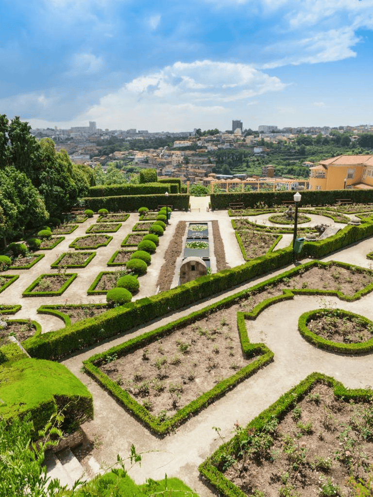 Elegant garden with manicured hedges and scenic city view in the background.