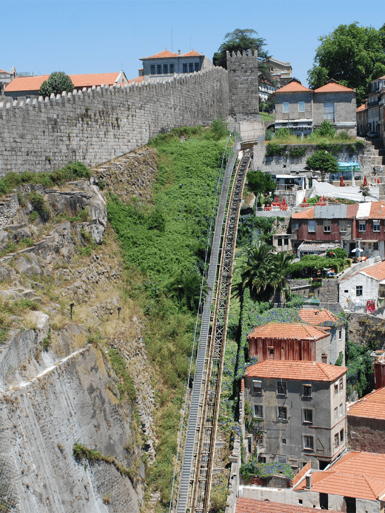 Historic city wall and funicular railway in Lisbon, Portugal, showcasing scenic urban landscape.