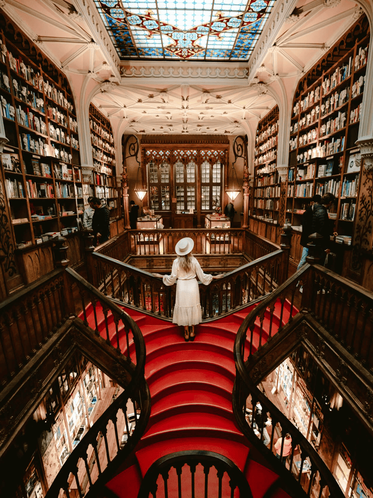 Cozy historic library with stained glass ceiling and grand staircase for reading and exploring books.