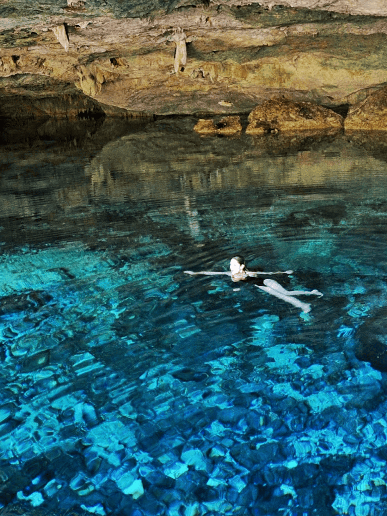 Crystal-clear underground cave swimming in vibrant blue waters.