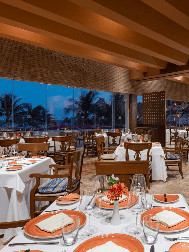 Elegant restaurant dining with sunset view and tropical scenery, perfect for special occasions and seaside dining.