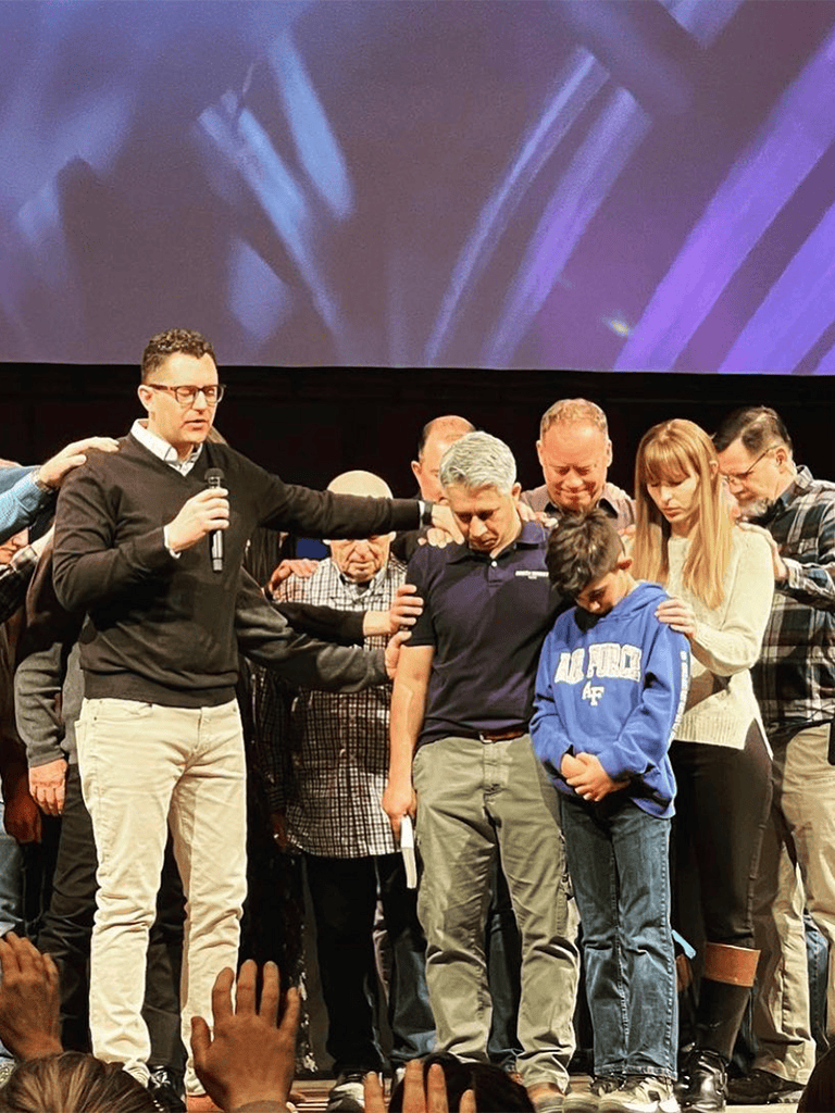 Healing prayer session on stage with diverse group of people, spiritual community, prayer, faith, and support.