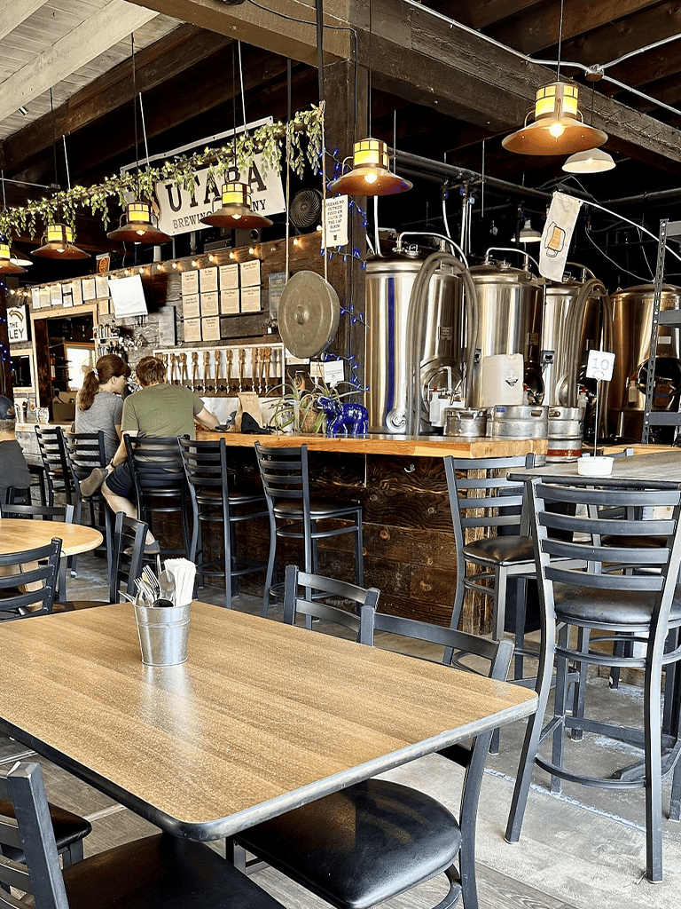 Cozy brewery interior with brewing tanks and rustic decor, inviting atmosphere for craft beer enthusiasts.