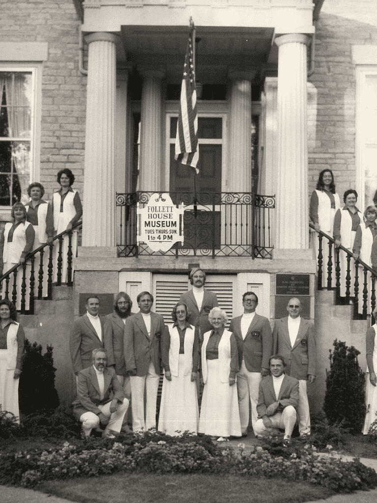 Historical group photo outside Follett House Museum with staff in uniforms.