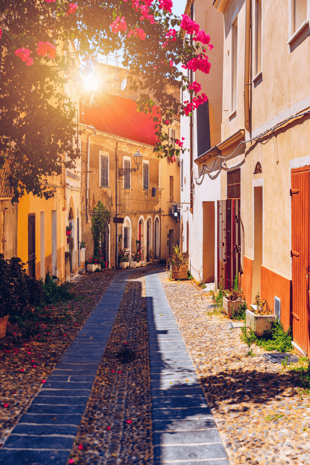Colorful Mediterranean street with vibrant flowers and historic buildings, perfect for travel inspiration.
