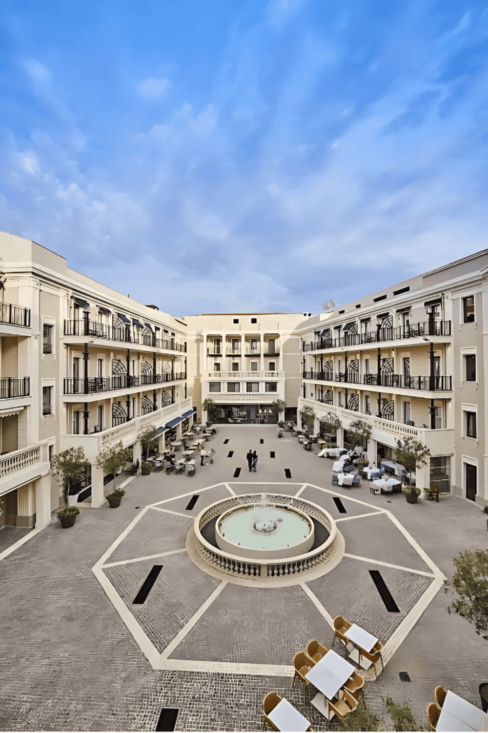Modern hotel courtyard with fountain and outdoor seating, perfect for travelers seeking comfort and relaxation.