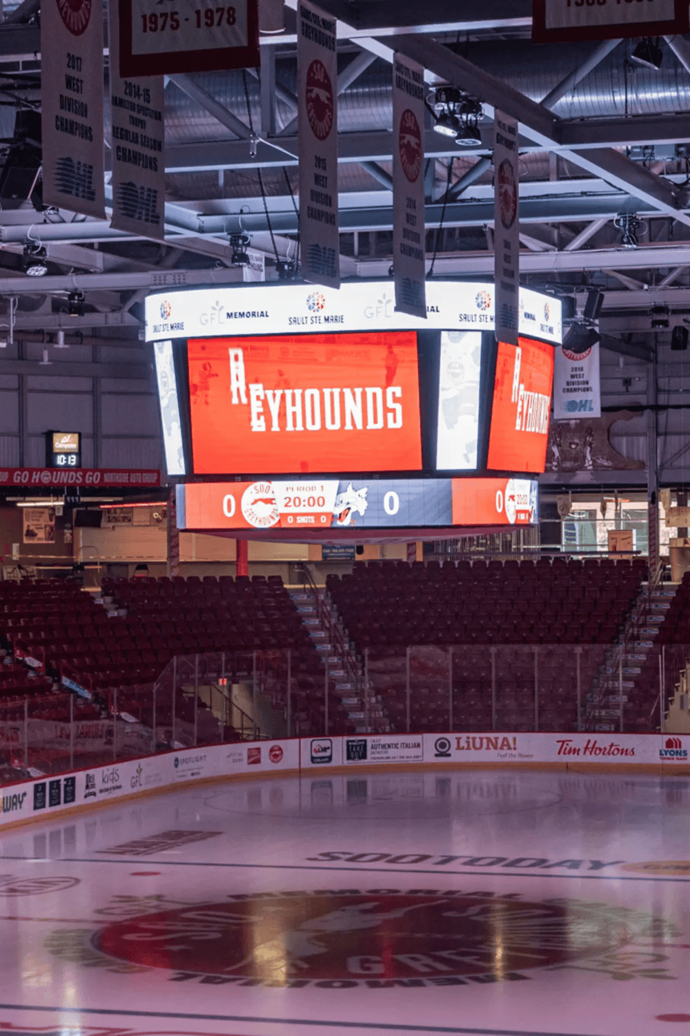 Arena scoreboard displaying QuestForDirections sponsorship, hockey game, and team info.