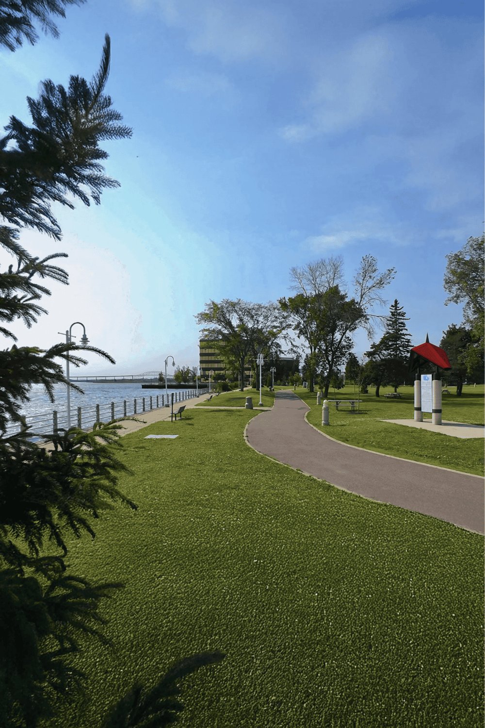 Serene riverside park with walking path, green lawns, and scenic views for outdoor relaxation.